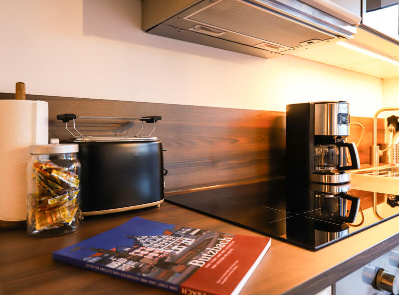 Küchenzeile mit Toaster, Kaffeemaschine und Stadtbuch über Butzbach